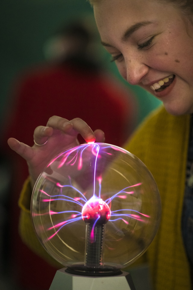 female student touching plasma ball